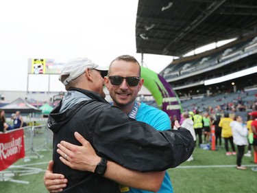 Sheldon Reynolds (left), who is a retired physical education teacher and also a retired coach education coordinator at Sport for Life Sport Centre, gives his nephew, James Corley	, a hug in the finishing area after Corley completed the Full Marathon at the 41st Manitoba Marathon in Winnipeg, Man., on Sunday, June 16, 2019.