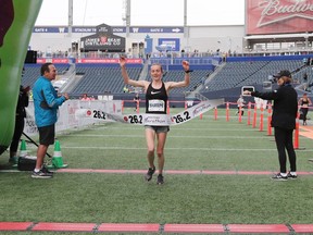 Winnipegger Selene Sharpe raises her arms as she wins the Women's Full Marathon at the 41st annual Manitoba Marathon in Winnipeg, on Sunday.