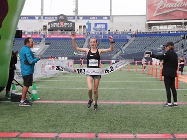 Winnipegger Selene Sharpe raises her arms as she wins the Women's Full Marathon at the 41st annual Manitoba Marathon in Winnipeg, Man., on Sunday, June 16, 2019.