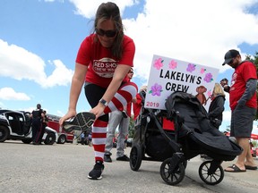 Kara Booth puts on her striped socks before the start of the the 5th annual Red Shoe Crew Walk in support of Ronald McDonald House Charities Manitoba, at the University of Manitoba, on Sunday. Booth's family and friends have supported the event since using the Ronald McDonald family room at Health Sciences Centre before her daughter Lakelyn died in 2015 at the age of seven months.