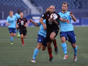 Valour FC forward Stephen Hoyle (centre) is bodied off the ball by HFX Wanderers FC defenders Peter Schaale (right) and Matthew Arnone during the first half of the second leg of its Canadian Championship match at IG Field in Winnipeg on Wed., June 7, 2019.  Hoyle has been let go and Valour has signed Spanish midfielder Jose Galan.
Kevin King/Winnipeg Sun/Postmedia Network