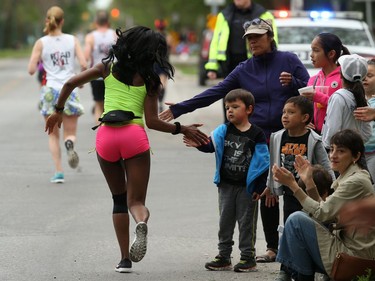 Spectators slap hands with runners on Harrow Street at Corydon Avenue during the Manitoba Marathon on Sun., June 16, 2019. Kevin King/Winnipeg Sun/Postmedia Network