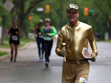 David Fielder, dressed as the Golden Boy, chugs along Harrow Street during the Manitoba Marathon on Sun., June 16, 2019. Kevin King/Winnipeg Sun/Postmedia Network