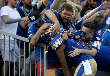 Winnipeg Blue Bombers receiver Darvin Adams is mobbed by fans while celebrating a touchdown from Nic Demski during CFL action against the Edmonton Eskimos in Winnipeg on Thurs., June 27, 2019. Kevin King/Winnipeg Sun/Postmedia Network