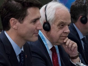 In this Nov. 14, 2018 photo, Canada's then-ambassador to China John McCallum sits next to Prime Minister Justin Trudeau, left, during a bilateral meeting with Chinese Premier Li Keqiang in Singapore.