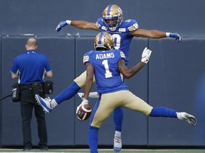 Winnipeg Blue Bombers' Darvin Adams (1) and Nic Demski (10) celebrate Adams' touchdown during first half against the Argonauts on Friday night. THE CANADIAN PRESS/John Woods
