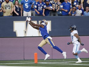 Bombers’ Darvin Adams hauls in the pass for the touchdown against the Toronto Argonauts last night. The Canadian Press)