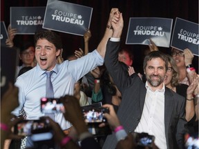 Prime Minister Justin Trudeau, left, raises the hand of Steven Guilbeault during an event to launch his candidacy for the Liberal party of Canada in Montreal, Wednesday, July 10, 2019.