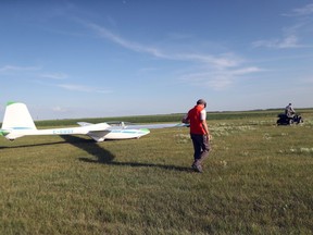 David Donaldson, who is the national safety officer for the Soaring Association of Canada, follows alongside a PW-6U sailplane as it's being towed to a runway at the Winnipeg Gliding Club, southwest of Winnipeg, on Wednesday.