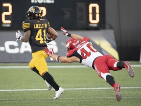 Hamilton Tiger Cats defensive back Will Likely III (41) evades the tackle from Calgary Stampeders linebacker Nate Holley (40) after he ran for a touchdown on a kick-off return during first half CFL football game action in Hamilton, Ont., on Saturday.