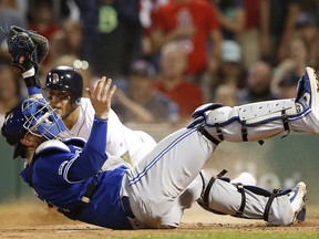 Toronto Blue Jays catcher Danny Jansen (9) holds up the ball after tagging out Boston Red Sox first baseman Michael Chavis (background) at home plate Monday at Fenway Park. (Greg M. Cooper-USA TODAY Sports)