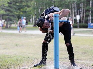 Winnipeg Folk Fest goer Aaron Badescu drinks water as he cools off during the 46th annual Winnipeg Folk Festival at Birds Hill Provincial Park, north east of Winnipeg, Man., on Thursday, July 11, 2019. This year's Festival runs July 11 to 14, 2019.