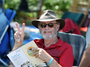 Winnipeg resident Laurie Simpson reads the Winnipeg Folk Festival program while relaxing at the 46th annual Winnipeg Folk Festival at Birds Hill Provincial Park, north east of Winnipeg, Man., on Saturday, July 13, 2019.