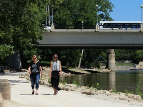 People travel on the riverwalk near the Main Street Bridge and the Forks in Winnipeg on Thursday, June 28, 2018. Rising river levels will cause the riverwalk until the end of the month.