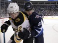 Winnipeg Jets defenceman Nathan Beaulieu (right) secures Boston Bruins centre Trent Frederic in Winnipeg on Thurs., March 14, 2019. Kevin King/Winnipeg Sun/Postmedia Network