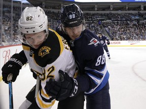 Winnipeg Jets defenceman Nathan Beaulieu (right) secures Boston Bruins centre Trent Frederic in Winnipeg on Thurs., March 14, 2019. Kevin King/Winnipeg Sun/Postmedia Network