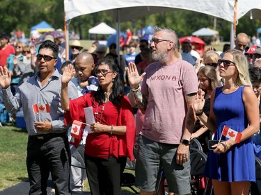 New citizens and supporters read the oath of citizenship during a special citizenship ceremony at Assiniboine Park in Winnipeg on Mon., July 1, 2019. Kevin King/Winnipeg Sun/Postmedia Network