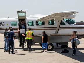 Residents of Little Grand Rapids arrive in Winnipeg on Sunday, after being evacuated from their homes due to heavy smoke drifting in from Ontario wildfires.