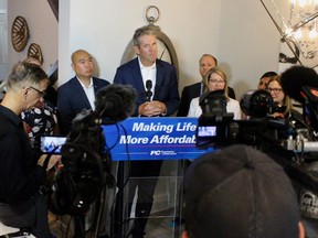 Premier Brian Pallister (centre) promised to eliminate the provincial sales tax on homeowners insurance if re-elected in the provincial election on Sept. 10, at a press conference in Winnipeg on Monday.
