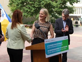 Federal Environment Minister Catherine McKenna (centre) shakes hands with Winnipeg environment committee chair Cindy Gilroy (left) at a climate change-related press conference in the Winnipeg City Hall courtyard on Friday.