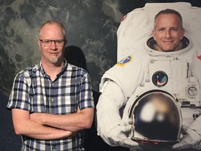 Scott Young (left), manager of the Planetarium and Science Gallery at the Manitoba Museum in Winnipeg, stands in front of a model of the moon and next to a cut-out of Canadian astronaut David Saint-Jacques in the Science Gallery on Saturday. The Manitoba Museum is marking the 50th anniversary of the first moon landing with a series of events.