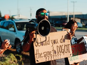 The group of about 15 activists from Manitoba Animal Save protest the Manitoba Stampede and Exhibition in Morris, Man., on Friday. The group waved signs calling for stampedes to be banned in Manitoba, claiming the events are outdated and cause unnecessary violence against the animals.