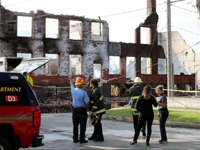 Winnipeg Fire Paramedic Service personnel discuss a warehouse fire on Jarvis Avenue on Monday, July 22