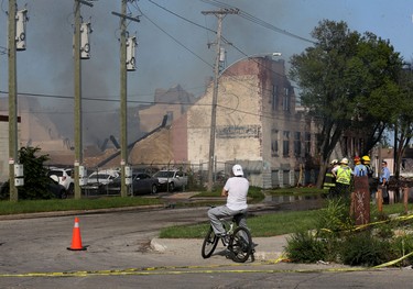 A man watches as a warehouse fire continues to smoulder on Jarvis Avenue on Mon., July 22, 2019. Kevin King/Winnipeg Sun/Postmedia Network