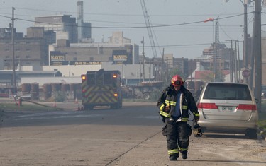 A firefighter walks through thick smoke at the scene of a warehouse fire on Jarvis Avenue on Mon., July 22, 2019. Kevin King/Winnipeg Sun/Postmedia Network