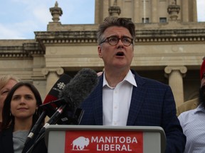 Manitoba Liberal Leader Dougald Lamount (centre) promises a Liberal government would create an independent commission to review Manitoba's tax system at a press conference at the Manitoba Legislature on Sunday.