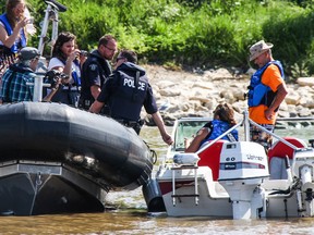 RCMP officers do a routine stop of a boat along the Red River.
