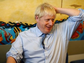 Britain's Prime Minister Boris Johnson meets with patient patient Logan Rock, 1, during his visit to the Royal Cornwall Hospital on August 19, 2019 in Truro, England.