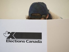 CP-Web. A woman marks her ballot behind a privacy barrier in the riding of Vaudreuil-Soulanges, west of Montreal, on election day on October 19, 2015.