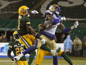 Edmonton Eskimo Monshadrik Hunter (left) and Winnipeg Blue Bomber Willie Jefferson (right) battle for possession of the ball during CFL action in Edmonton on Friday.