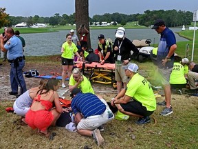 Fans are assisted by medical personnel after a lightning strike during the third round of the Tour Championship golf tournament at East Lake Golf Club.