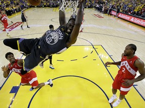 Golden State Warriors forward Draymond Green dunks the ball against Toronto Raptors centre Serge Ibaka and forward Kawhi Leonard in game six of the 2019 NBA Finals at Oracle Arena.