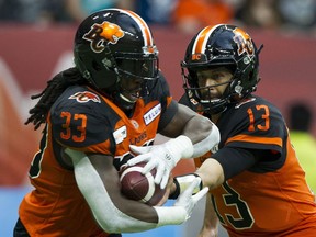 BC Lions QB Mike Reilly hands off to Wayne Moore.