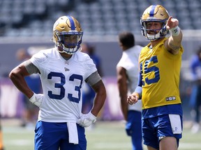 Quarterback Matt Nichols (right) and running back Andrew Harris review a play during Winnipeg Blue Bombers practice at IG Field on Monday.