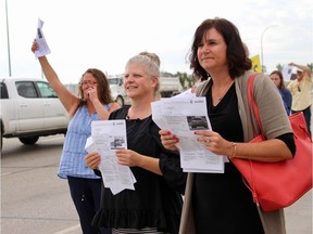 Carmel Antonishin (right) and Kelly Antonation (middle) hold up seven tickets between them, during a WiseUpWinnipeg protest on Tuesday. All, they say, have come in the past month from the same poorly marked designation construction zone on a stretch of southbound Route 90 close to Inkster Boulevard.