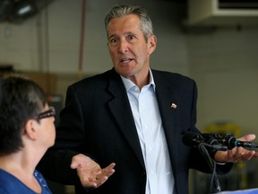 Premier Brian Pallister gestures during a press conference at Vernaus Auto Body on Higgins Avenue in the Point Douglas area of Winnipeg on Tues., Aug. 13, 2019. The ruling Progressive Conservatives promised to reduce the vehicle registration fee if re-elected on Sept. 10. Kevin King/Winnipeg Sun/Postmedia Network