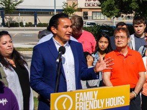 NDP Leader Wab Kinew (centre) is joined by NDP candidates and their families to announce a proposed pilot project to extend hours at a South Winnipeg clinic on Sunday.
