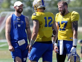 Injured quarterback Matt Nichols (left) jokes with fellow QBs Sean McGuire (centre) and Chris Streveler during Winnipeg Blue Bombers practice on the University of Manitoba campus in Winnipeg on Monday.