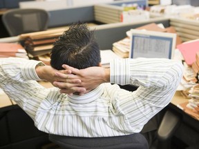 Businessman in cubicle with laptop and stacks of files   Credit: Fotolia // 1224-biz-xFPlevitt ORG XMIT: POS1507141058540254