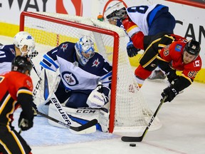 Calgary Flames' Andrew Mangiapane attempts the wrap-around on Jets goalie Eric Comrie during Tuesday's game. (AL CHAREST/Postmedia Network)