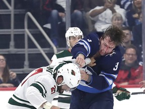 Jets defenseman Tucker Poolman (3) and Minnesota Wild left wing Mike Liambas (27) fight on Wednesday night. at Bell MTS Place. James Carey Lauder-USA TODAY Sports