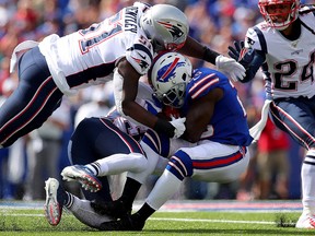 Frank Gore of the Buffalo Bills gets tackled by Devin McCourty and Ja'Whaun Bentley of the New England Patriots at New Era Field on September 29, 2019 in Buffalo. (Brett Carlsen/Getty Images)