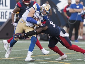 Winnipeg Blue Bombers quarterback Chris Streveler, left, is tackled by Montreal Alouettes linebacker Henoc Muamba in Montreal, Saturday. (The Canadian Press)