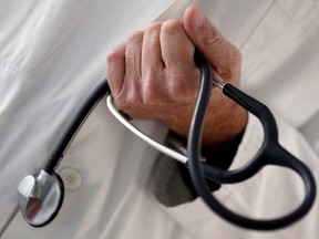 A photo illustration shows a general practitioner holding a stethoscope in a doctor's office.