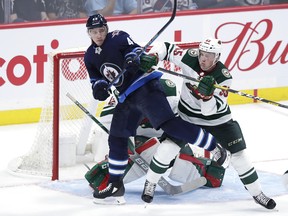 Minnesota Wild defenceman Nick Seeler (55) checks Winnipeg Jets' Andrei Chibisov (48) in  front of goaltender Mat Robson during pre-season play on Wednesday night at Bell MTS Place. (James Carey Lauder-USA TODAY Sports)