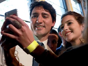 In this April 16, 2018, Prime Minister Justin Trudeau (L) poses for a selfie as he leaves after speaking at the "Sciences-Po" political science university in Paris.